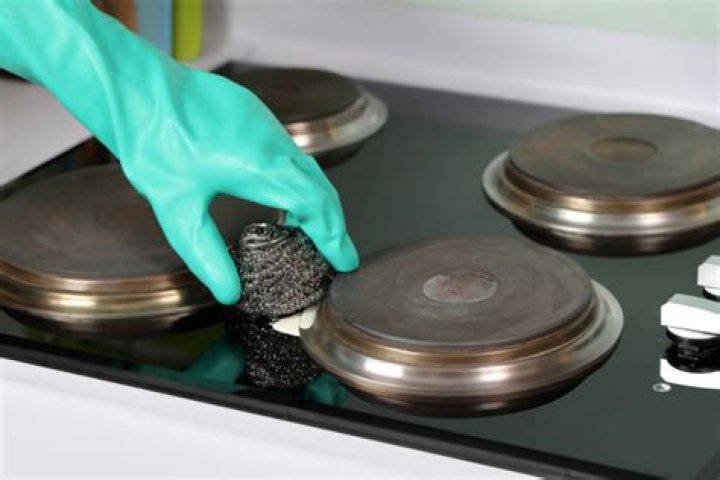 How do I clean the solid plate on my electric hob