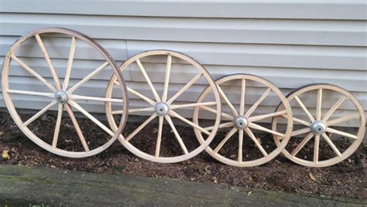 How is a metal rim fixed around the wooden wheel of a cart